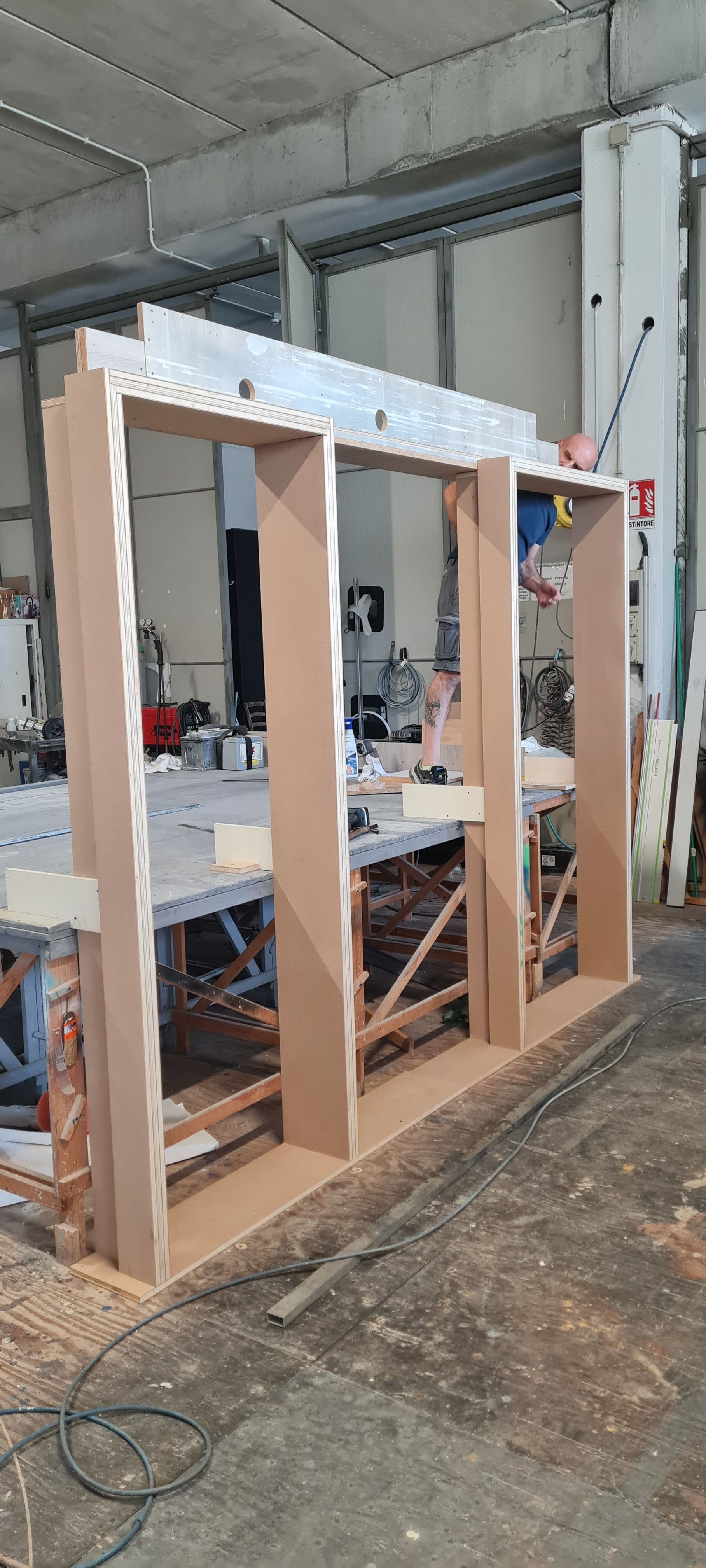Struttura in legno del telaio delle porte scorrevoli in fase di costruzione nel laboratorio artigianale